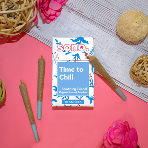 Image Description: A cardboard smoke pack titled Time to Chill, referring to the herbal smoking blend that the 10 smokes inside are filled with. Beneath the title are the words Soothing Blends, & Organic Herbal Smokes. The box is decorated with blue floral shapes designed to look like the ingredients inside: Marigold, Klip Dagga, Rosemary, Mullein, Skullcap & Lavender. With the pack are 3 herbal prerolls, also known as Herbal Spliffs, Herbal Cigarettes, Herbs & Flowers Smokes, or Herb Tokes.